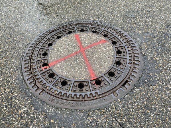 Kanaldeckel mit rotem Kreuz werden saniert