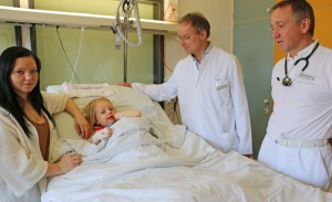 Die kleine Vivienne mit ihrer Mama und ihren behandelnden Ärzten: Kinderklinikchefarzt Professor Dr. Martin Ries (ganz rechts) und Kinderchirurg Dr. Alfred Heger (daneben). Foto: Häfele/Klinikum Memmingen