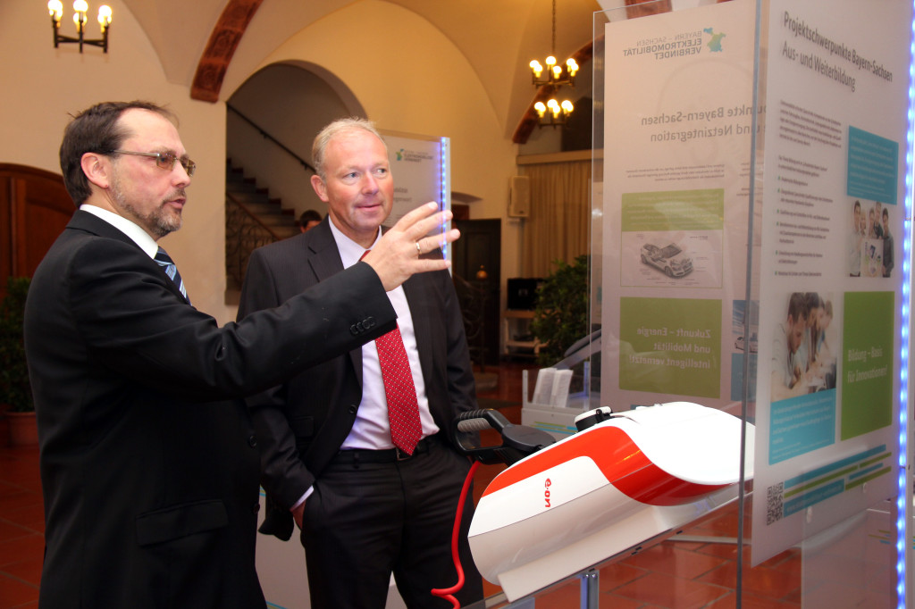 Der Ausstellungskoordinator Dr. Guido Weißmann (links) führt den Vorstand der Lechwerke, Norbert Schürmann, in die Wanderausstellung zum Thema Elektromobilität ein.