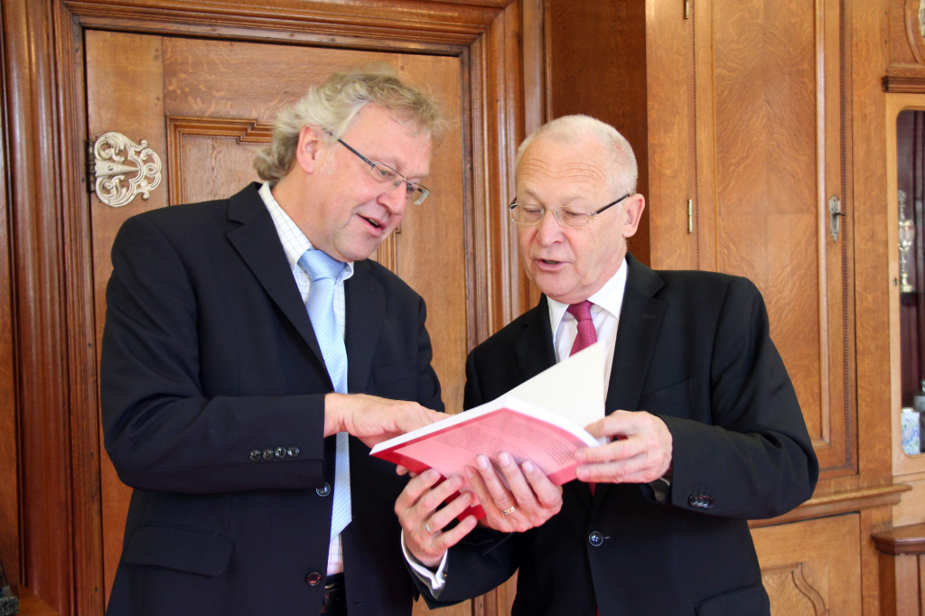 18 Jahre hat der Memminger Musikschulleiter Otfried Richter (links) an der Biografie über den jüdischen Exilkomponisten Werner Wolf Glaser gearbeitet. Das erste Exemplar der druckfrischen Ausgabe überreichte er jetzt Memmingens Oberbürgermeister Dr. Ivo Holzinger im Rathaus.Foto: Häfele/Pressestelle Stadt Memmingen 