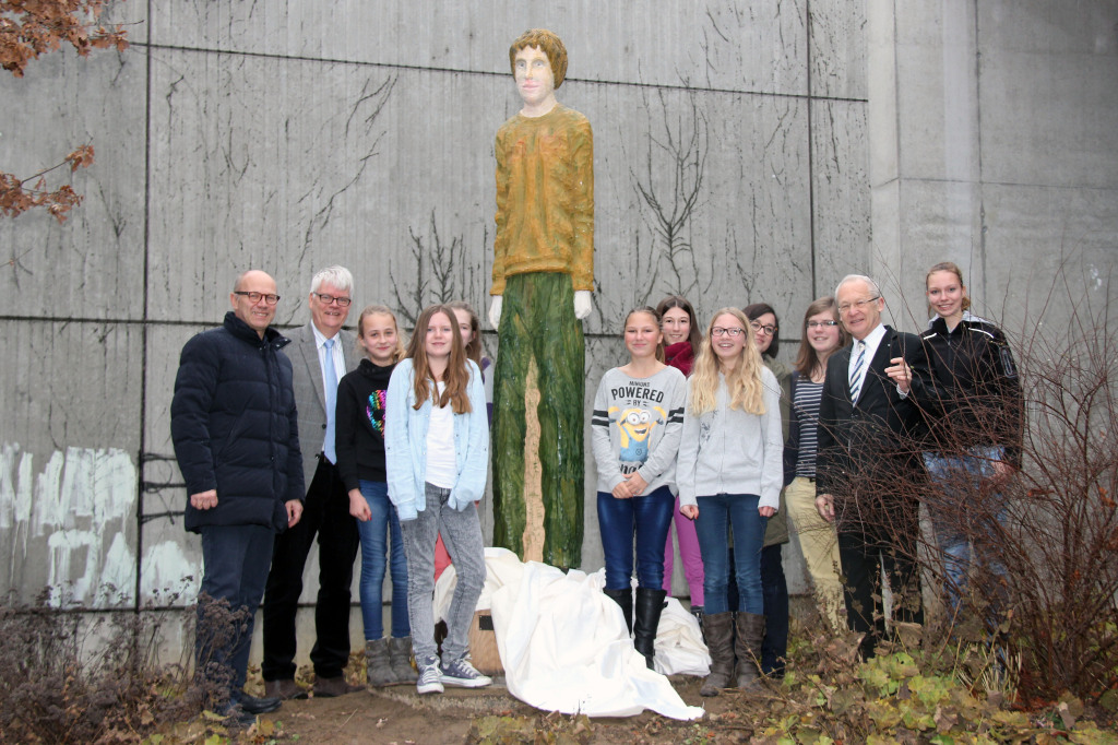 Vor der Aula des Vöhlin-Gymnasiums haben Schülerinnen die neue Holzskulptur von Robert Koenig enthüllt. Mit dabei waren Oberbürgermeister Dr. Ivo Holzinger (2.v.re.), Kulturreferentin Isabella Salger (4.v.re.), Rektor Burkhard Arnold (2.v.li.) und Kulturamtsleiter Dr. Hans-Wolfgang Bayer (li.). (Fotos: Mayer/Pressestelle Stadt Memmingen)