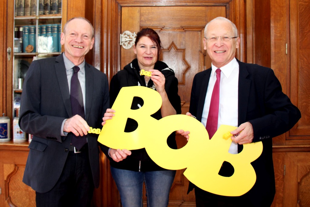 Der knallgelbe Schriftzug „BOB“ steht für Verantwortung und richtet sich damit gegen Alkohol am Steuer. Bei der Vorstellung des „BOB“-Präventionsprojekts im Amtszimmer von Memmingens Oberbürgermeister Dr. Ivo Holzinger (rechts): Stadtjugendpflegerin Christina Übele und Sozialreferatsleiter Manfred Mäuerle (links). Foto: Häfele/Pressestelle Stadt Memmingen 