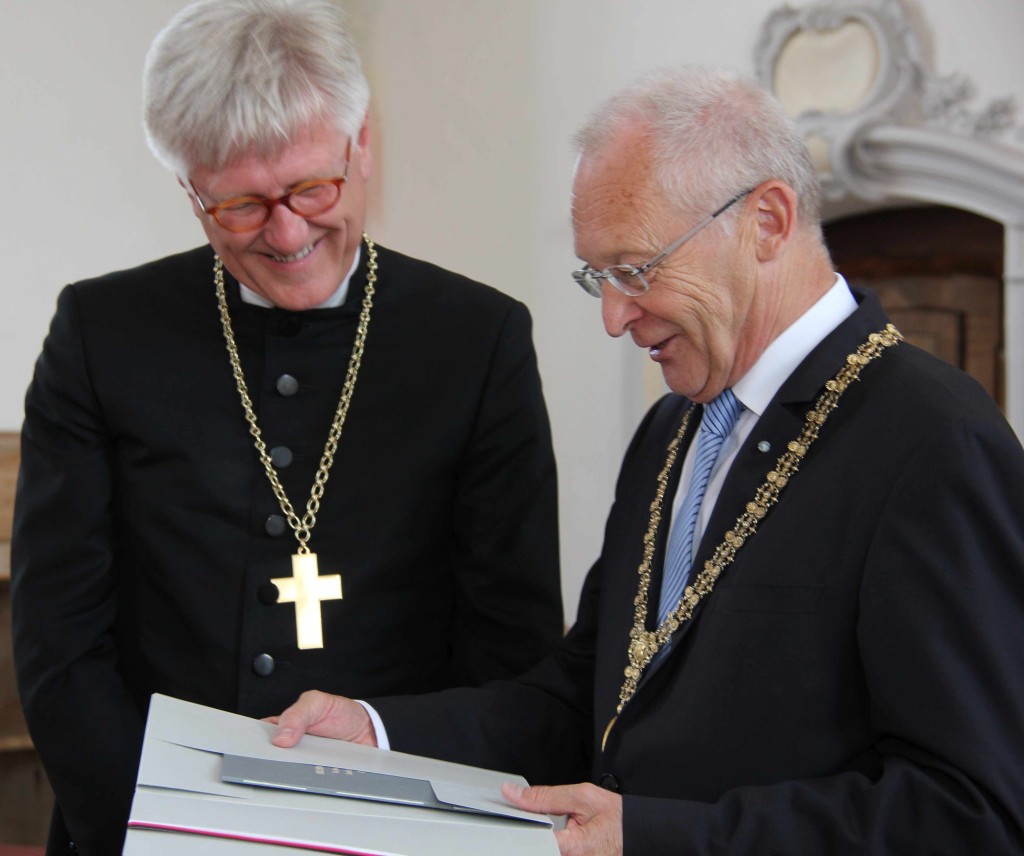 Oberbürgermeister Dr. Ivo Holzinger (rechts) überreicht Landesbischof Dr. Heinrich Bedford-Strohm eine gebundene Farbkopie des handschriftlichen Originals der Kirchenordnung der Reichsstadt Memmingen aus dem Jahr 1569.